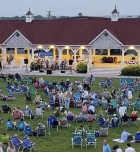 Park with concert stand people sitting on lawn