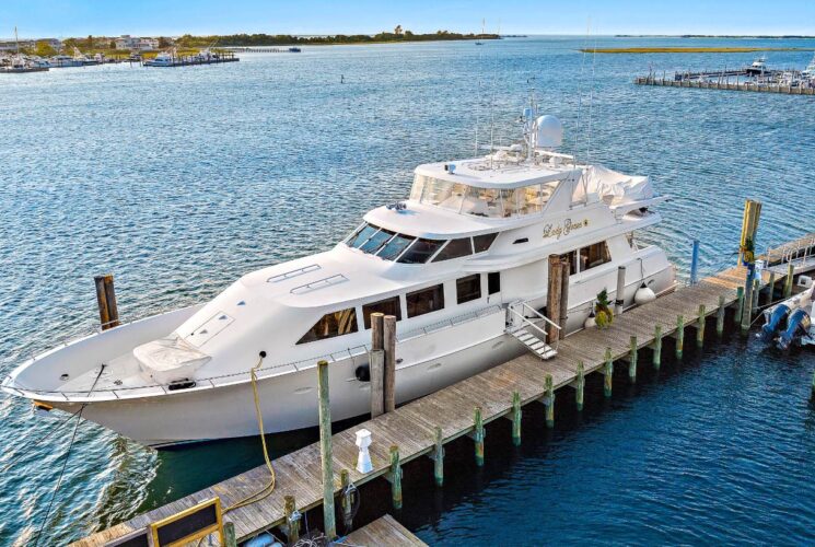 White yacht docked at wooden pier in marina