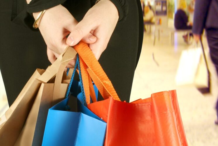 Close up view of a person holding multiple shopping bags