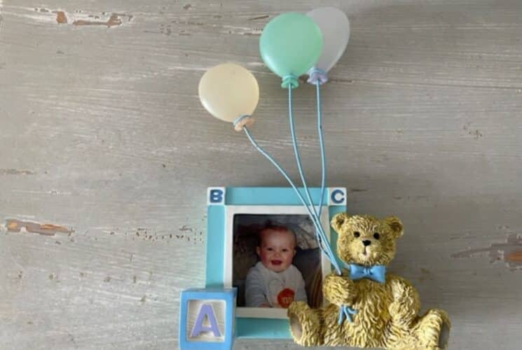 Picture of baby in a frame with bear & balloons