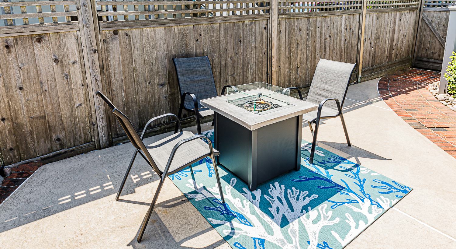 Backyard patio with patio chairs and gas firepit