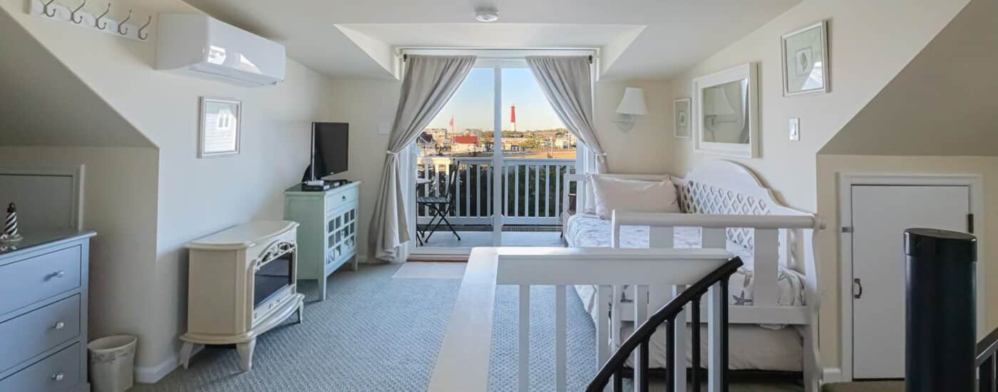 Bedroom with white walls, carpeting, daybed, balcony patio, and spiral staircase