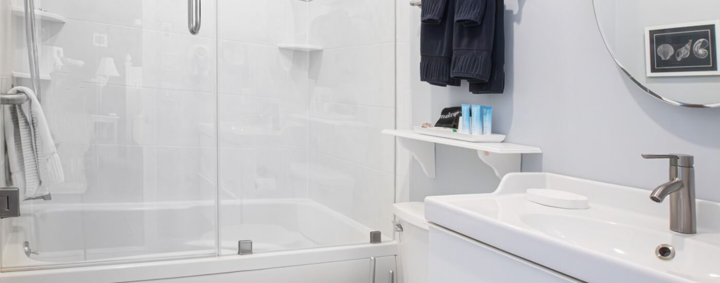 Bathroom with light gray walls, shower/tub combo, white vanity, and white countertop