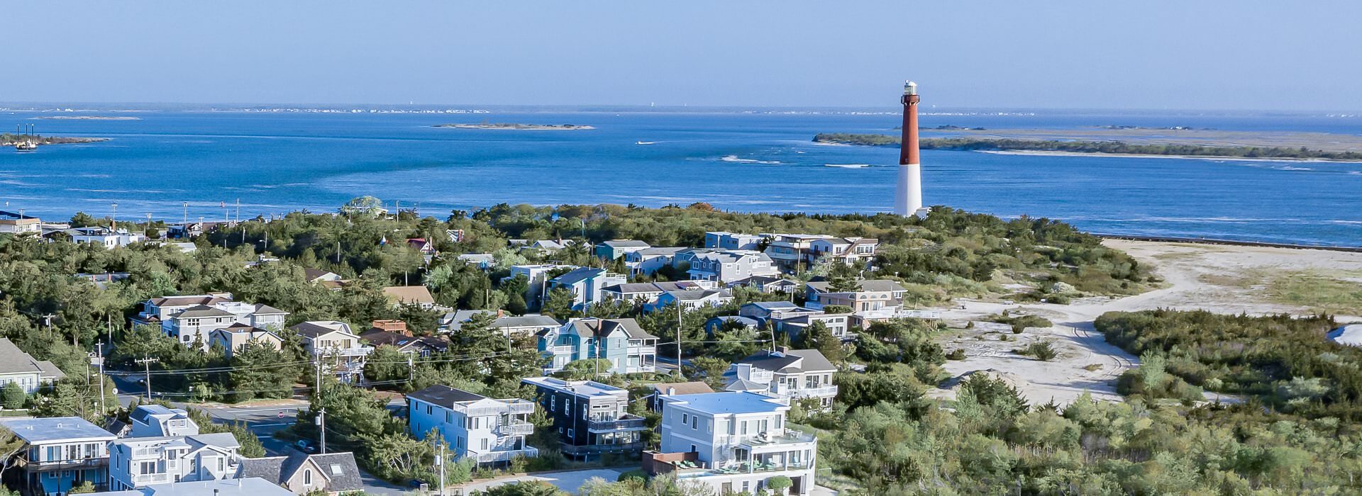 Aerial view of a coastal town with a lighthouse near the ocean