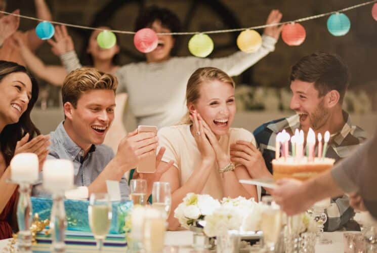 People sitting at a table, smiling, and celebrating a birthday