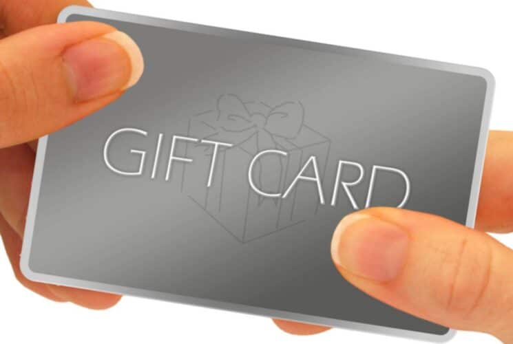 Close up view of a gray gift card held by two hands