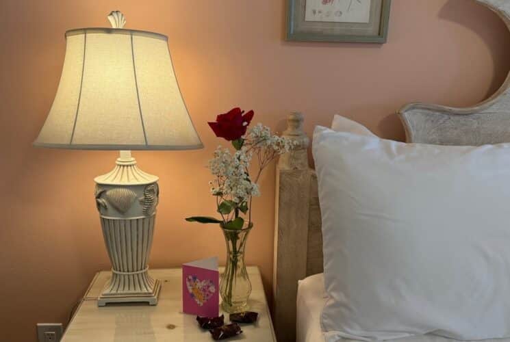 red rose on a side table with a card