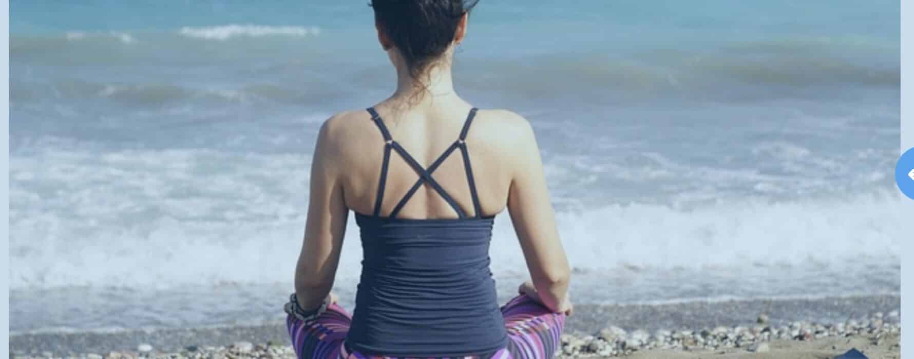 women sitting at shore on yoga matt