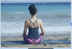 women sitting at shore on yoga matt