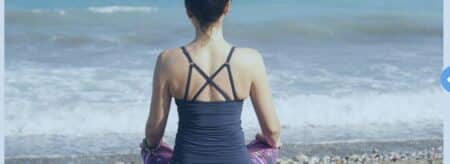 women sitting at shore on yoga matt